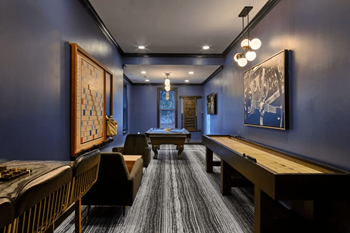 A game room with a pool table and a billiard table